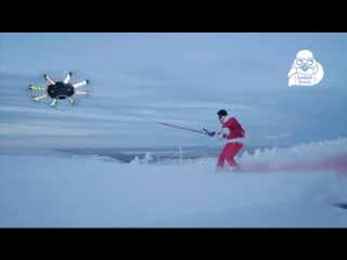 snowboarder rides and flies behind an octocopter